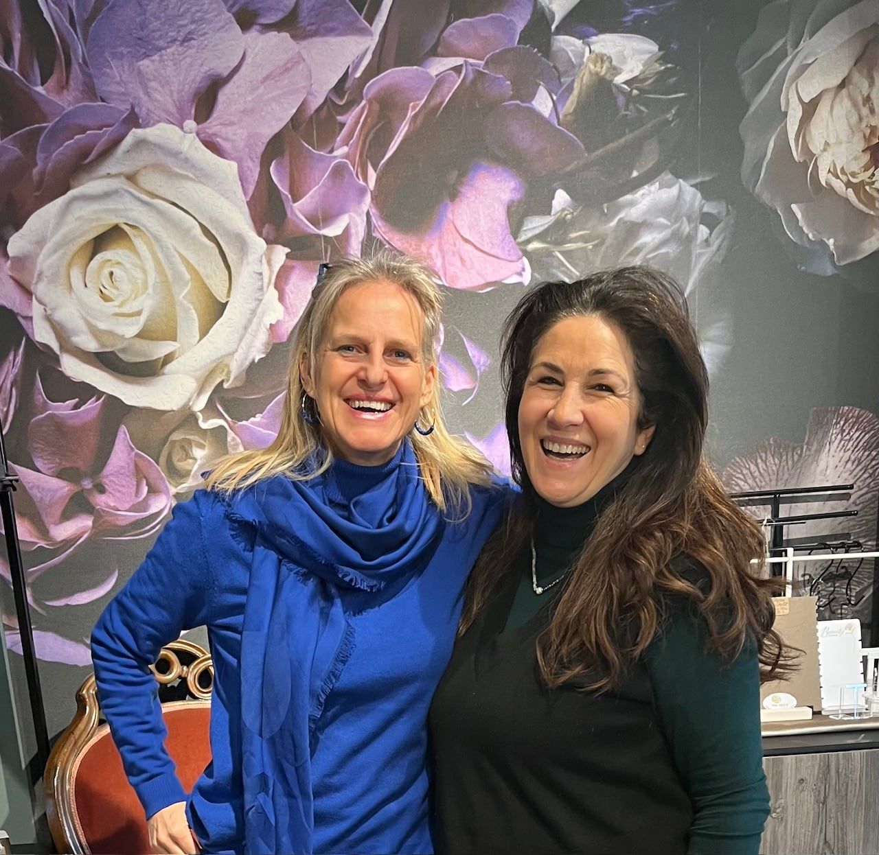 Nicole Rupp und Nalan lachend vor einer Wand mit großen Rosen im Laden Für mich in Haar